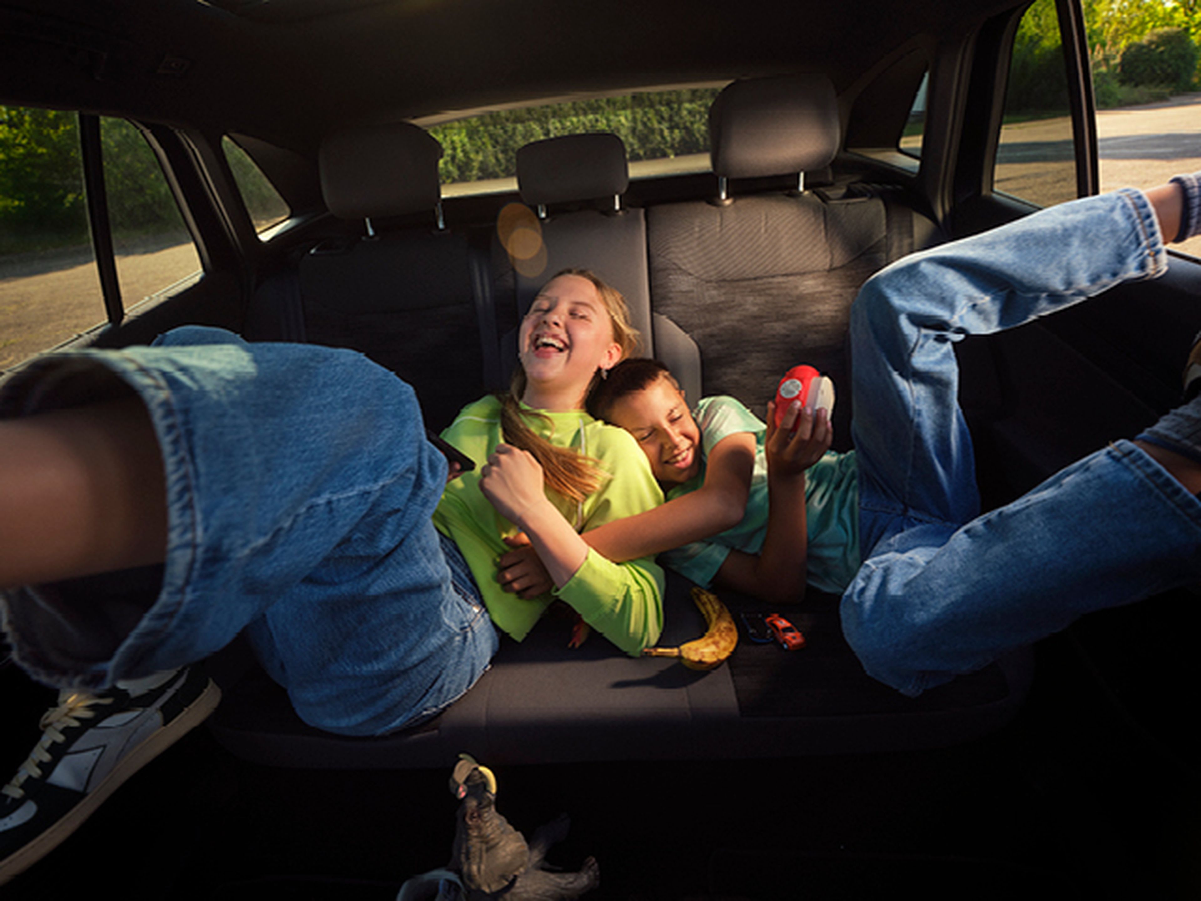Famille dans la voiture avec homme rechargeant voiture électrique chez Q8.