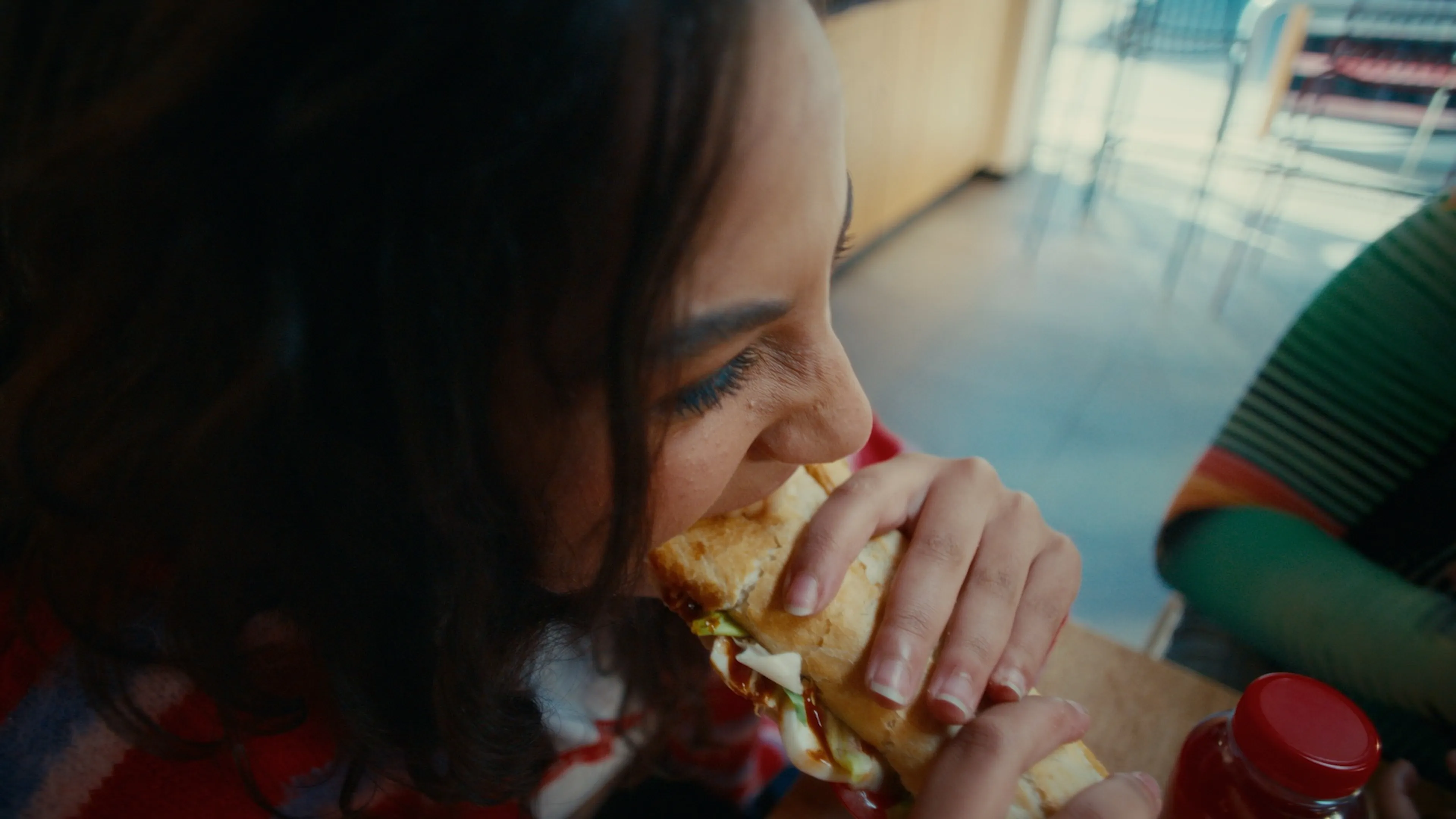 Femme mord dans un sandwich Panos dans une station Q8