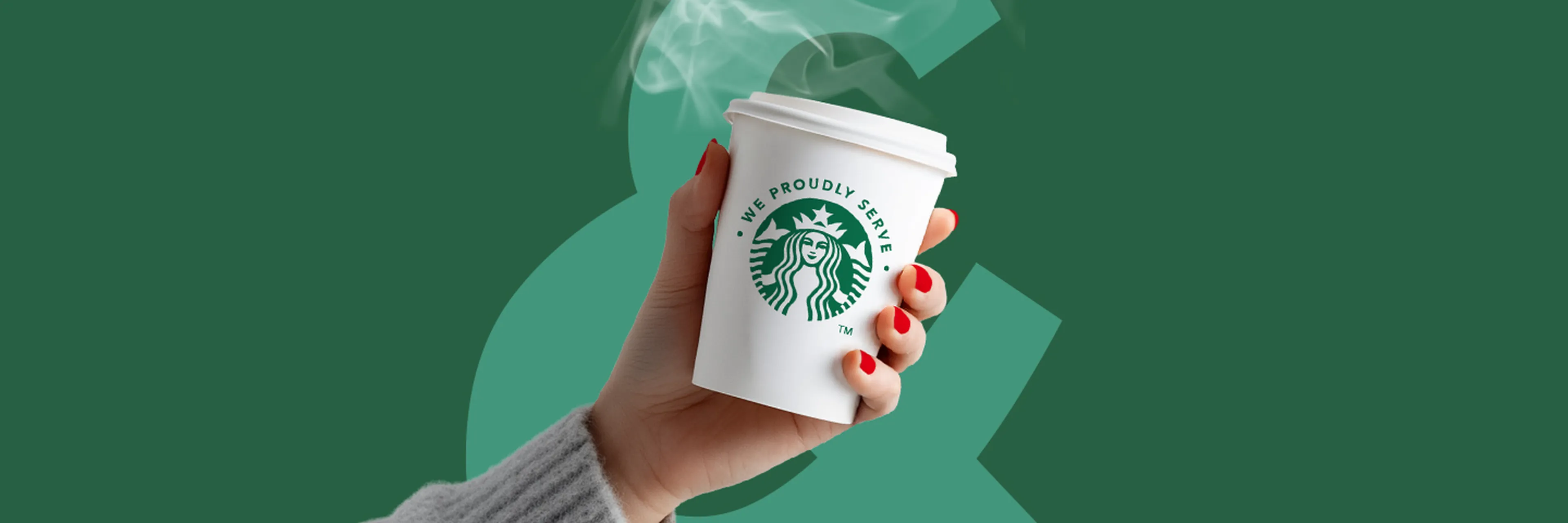 Main tenant un gobelet Starbucks fumant avec le logo 'We Proudly Serve' sur fond vert