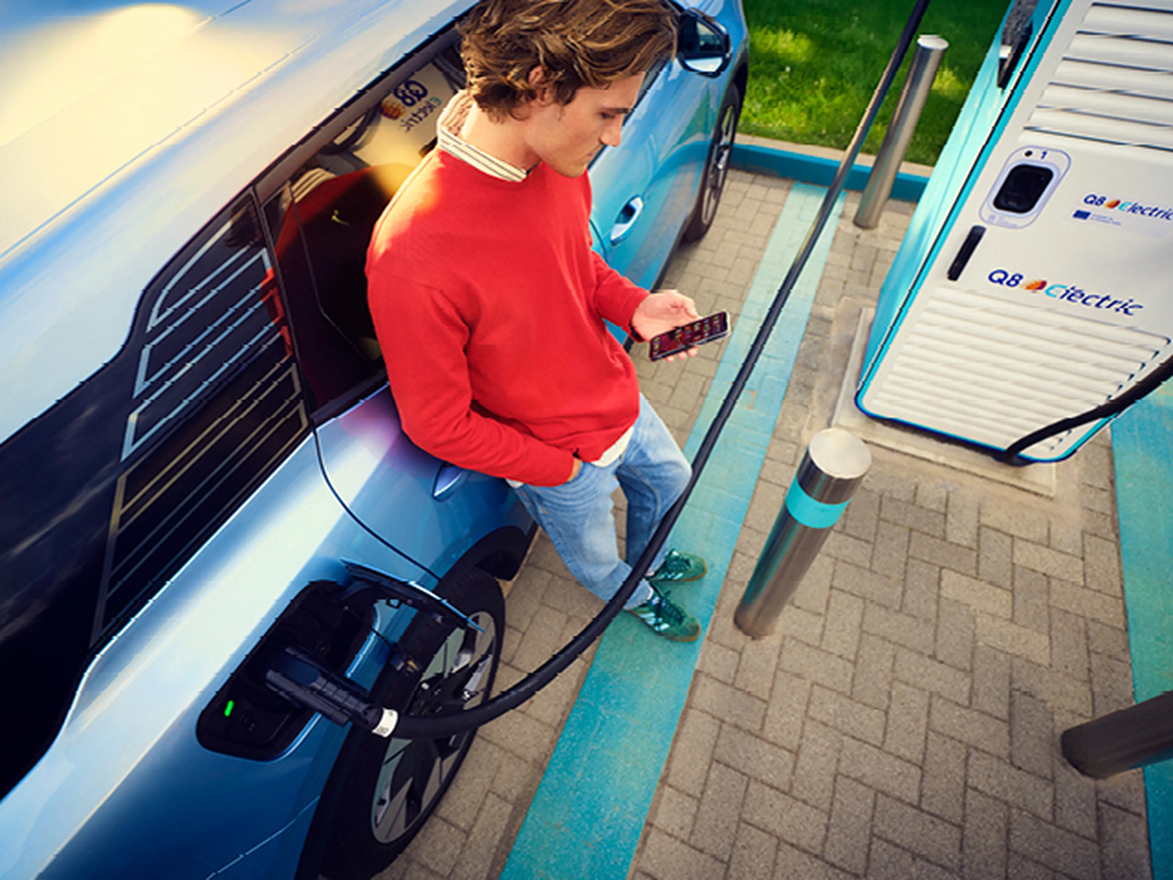 Homme recharge voiture électrique chez Q8 Electric.​