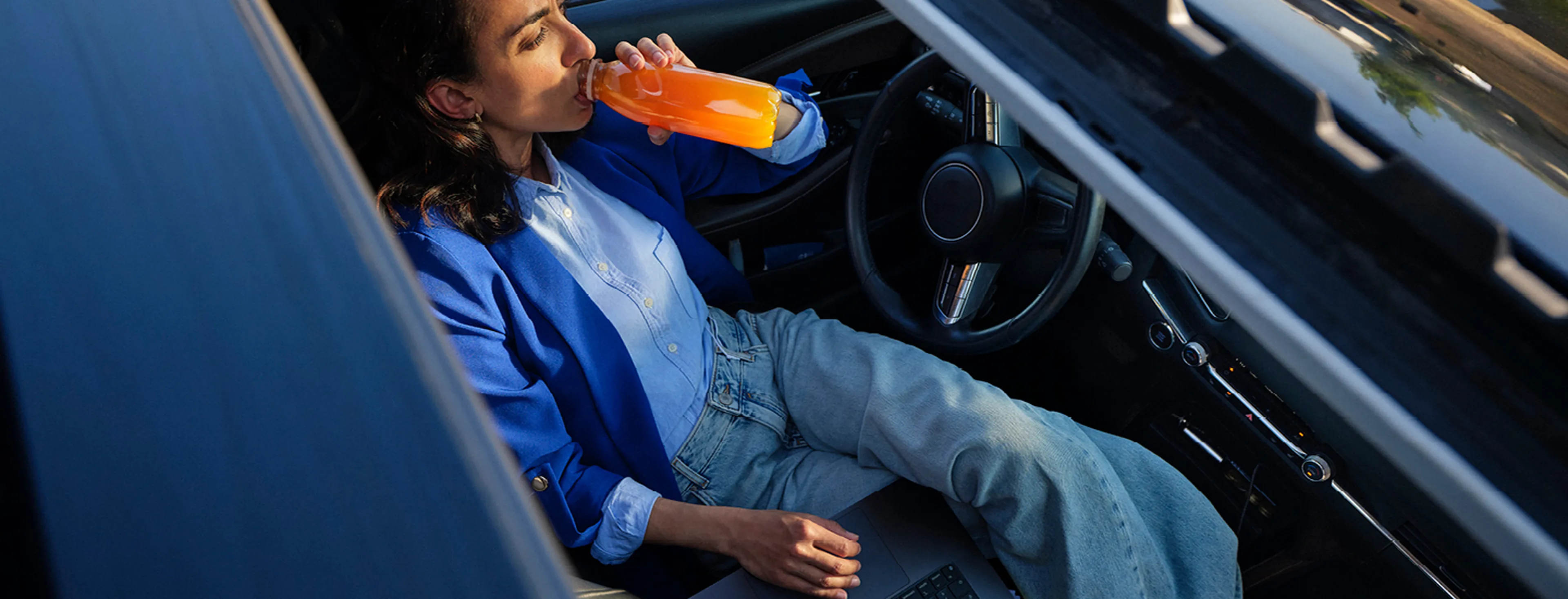 Femme travaille sur ordinateur portable en voiture chez Q8