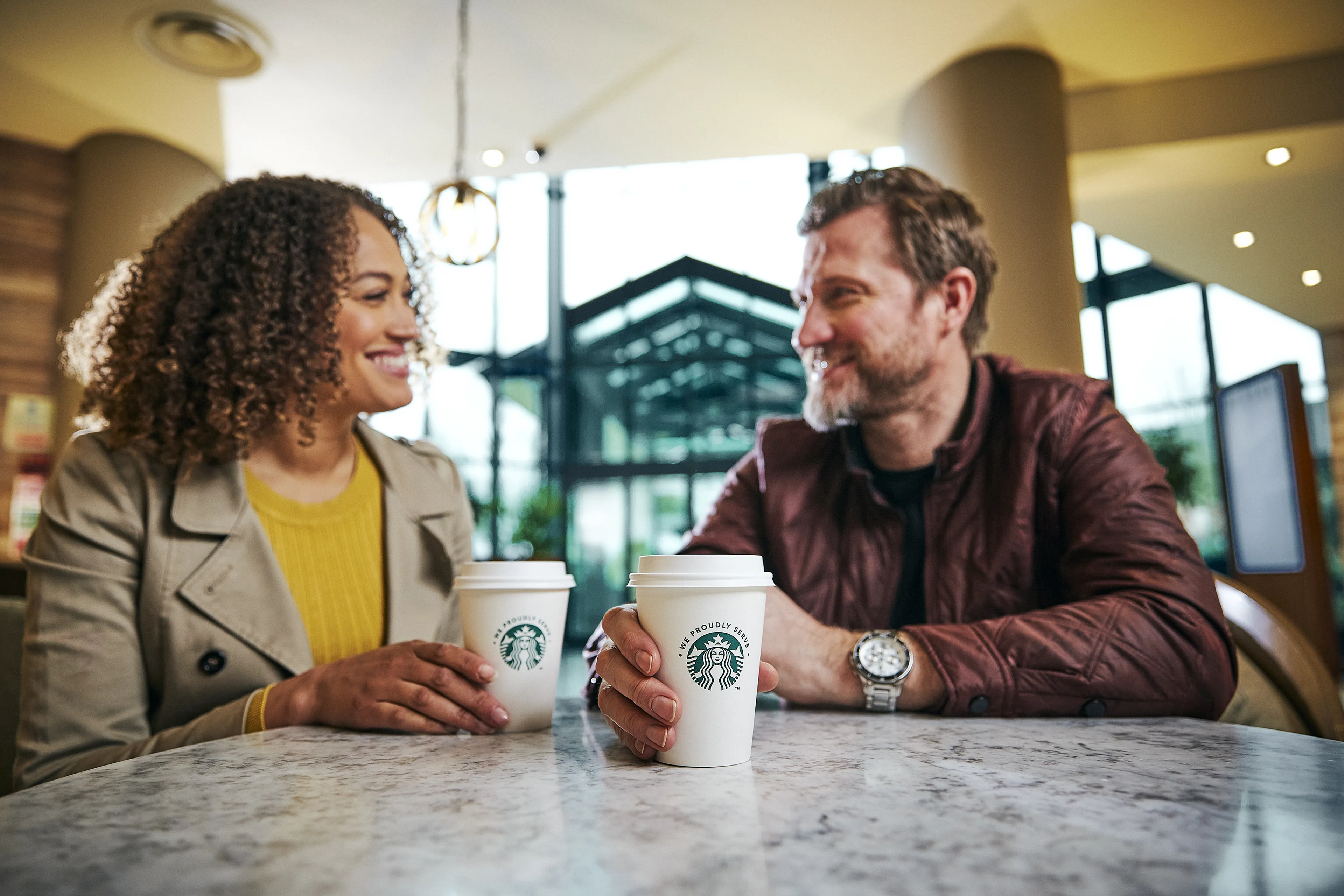Deux personnes savourent un café Starbucks dans une ambiance conviviale