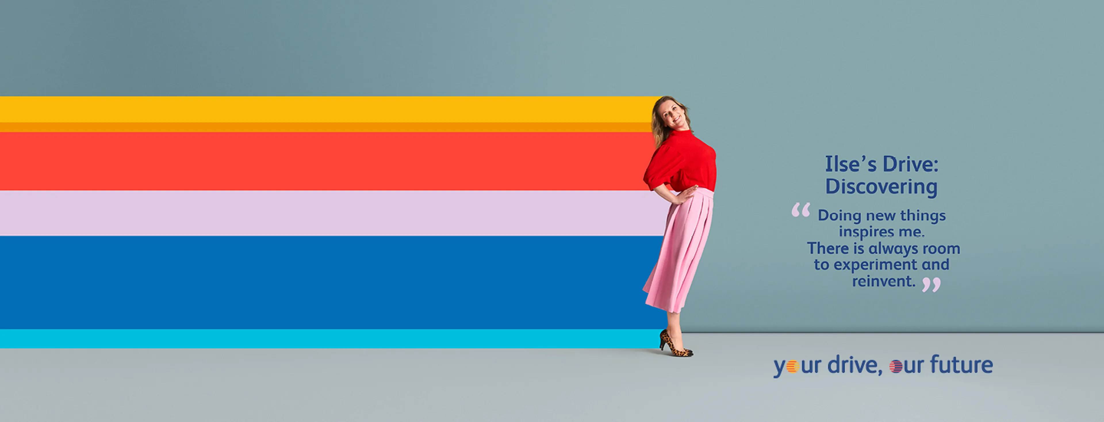 Femme aux cheveux noirs et chemise rouge avec un pantalon jaune, posant joyeusement en tant qu’employée Q8.