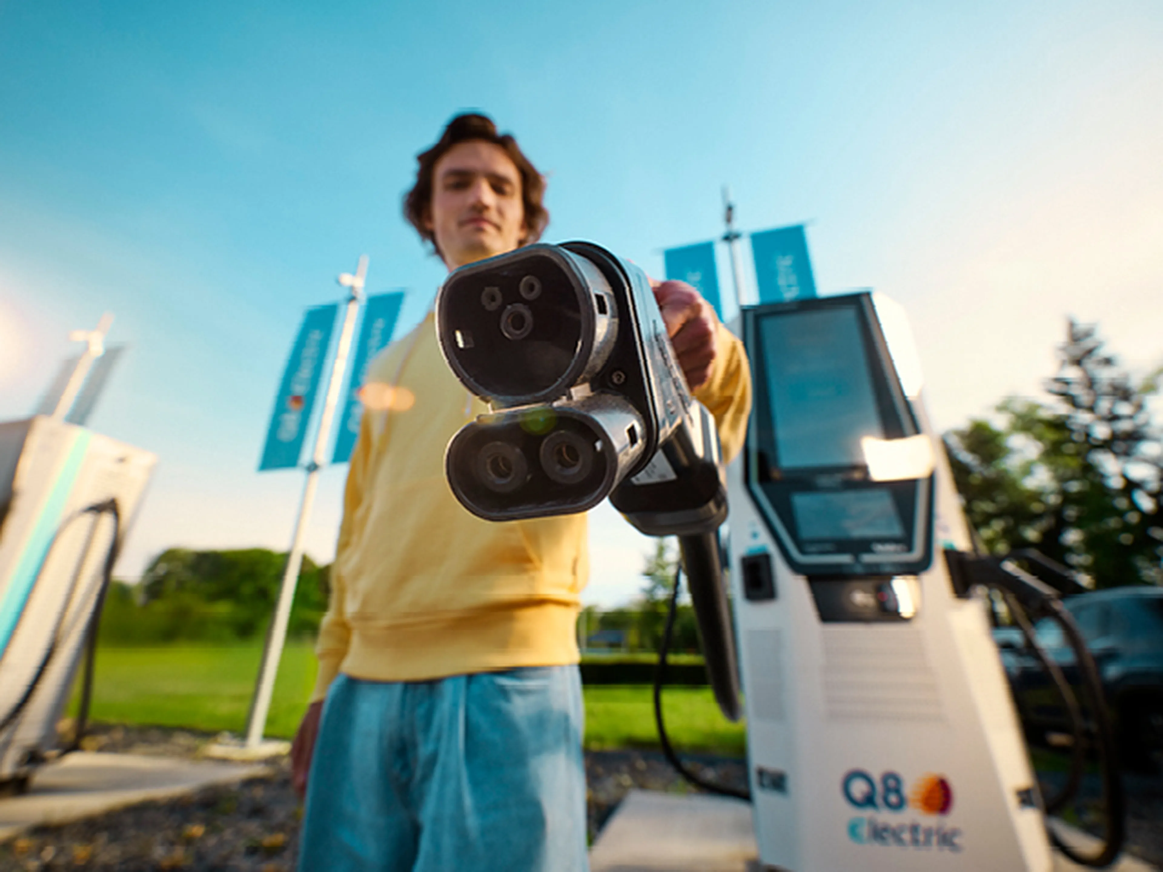 Homme montre une prise de recharge Q8 Electric à la caméra