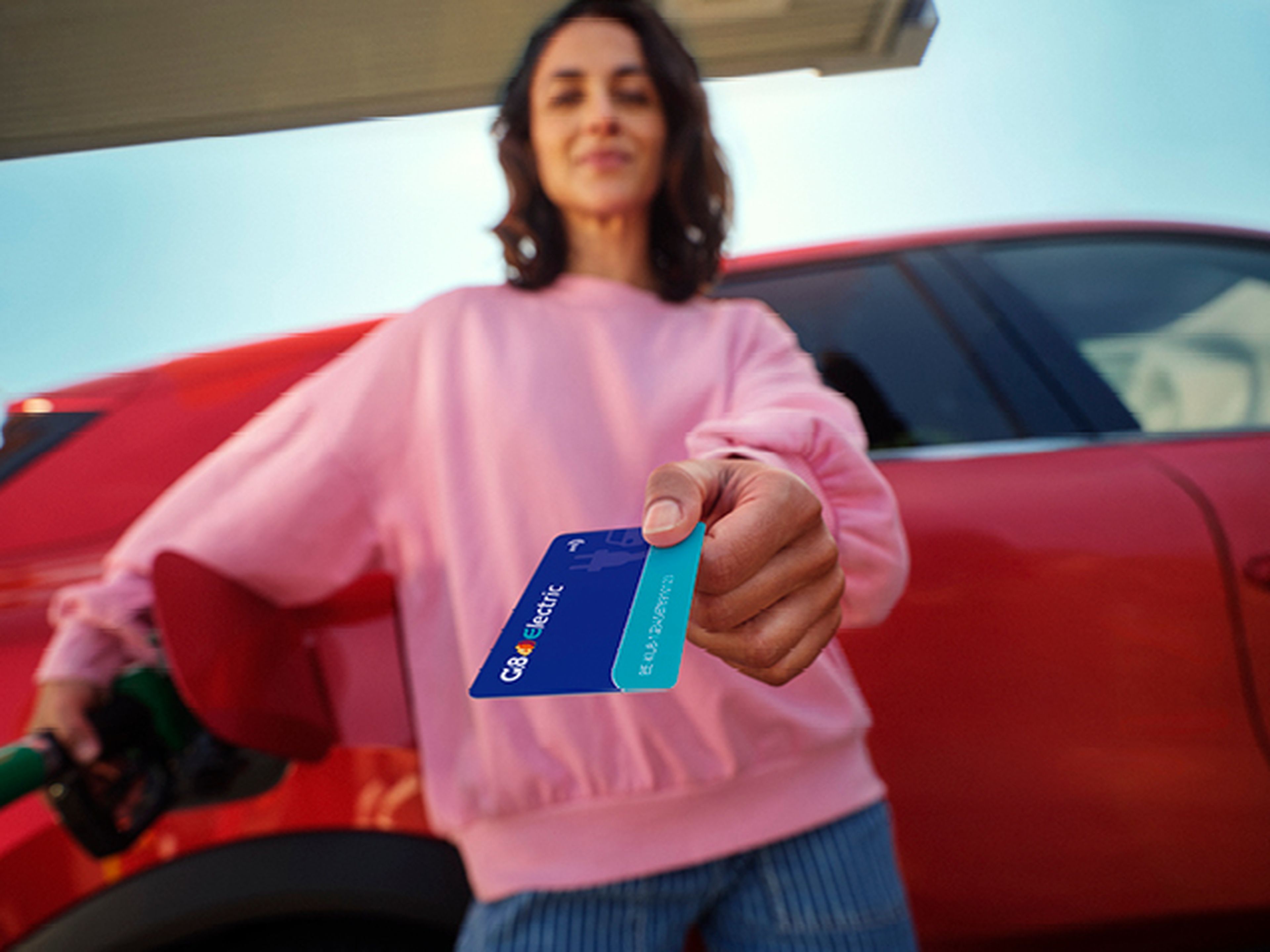 Une femme tient une carte Q8 electric