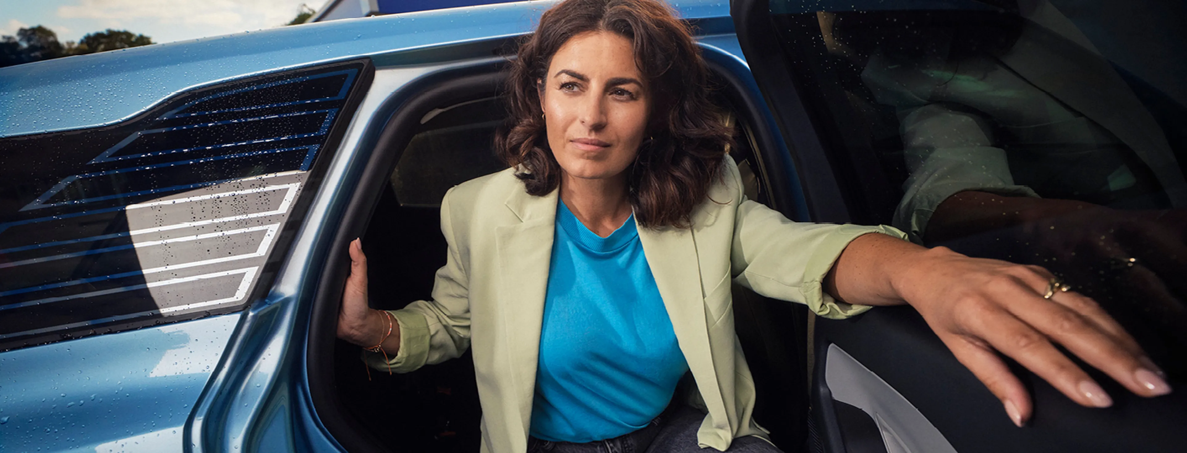Femme sort de la voiture bleue chez Q8.