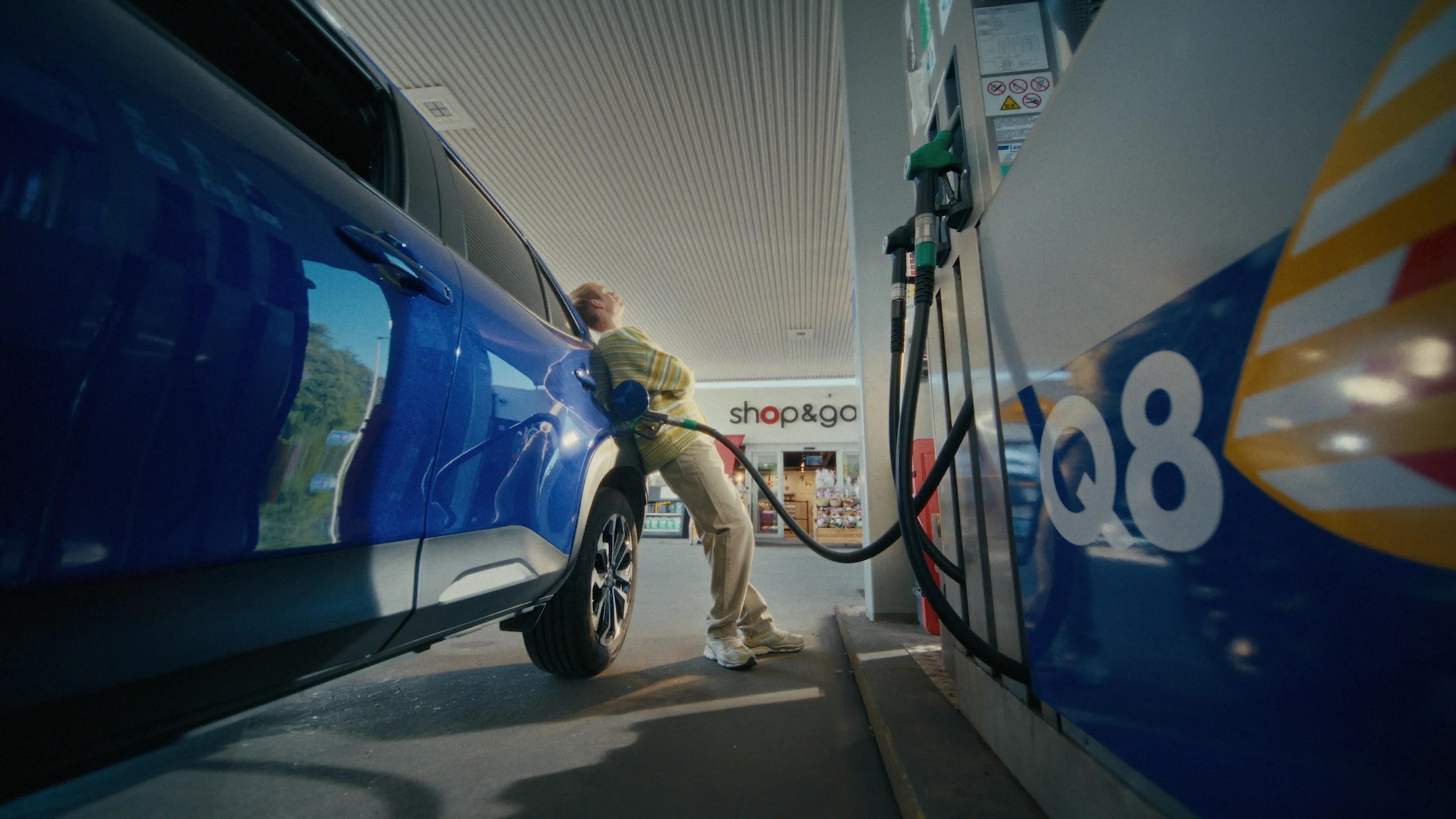 man die aan het tanken is bij een Q8 tankstation