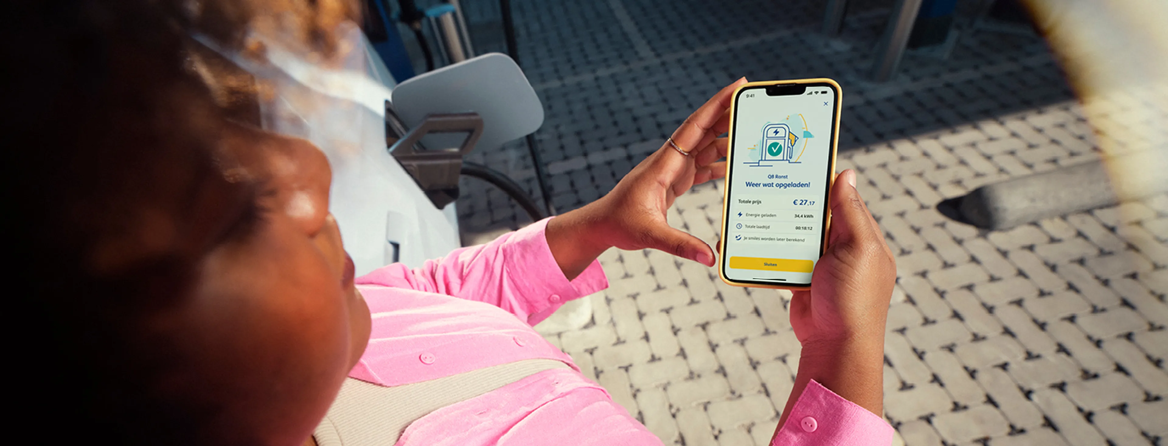 vrouw die de Q8 app gebruikt tijdens het opladen van een elektrische wagen bij Q8 electric.