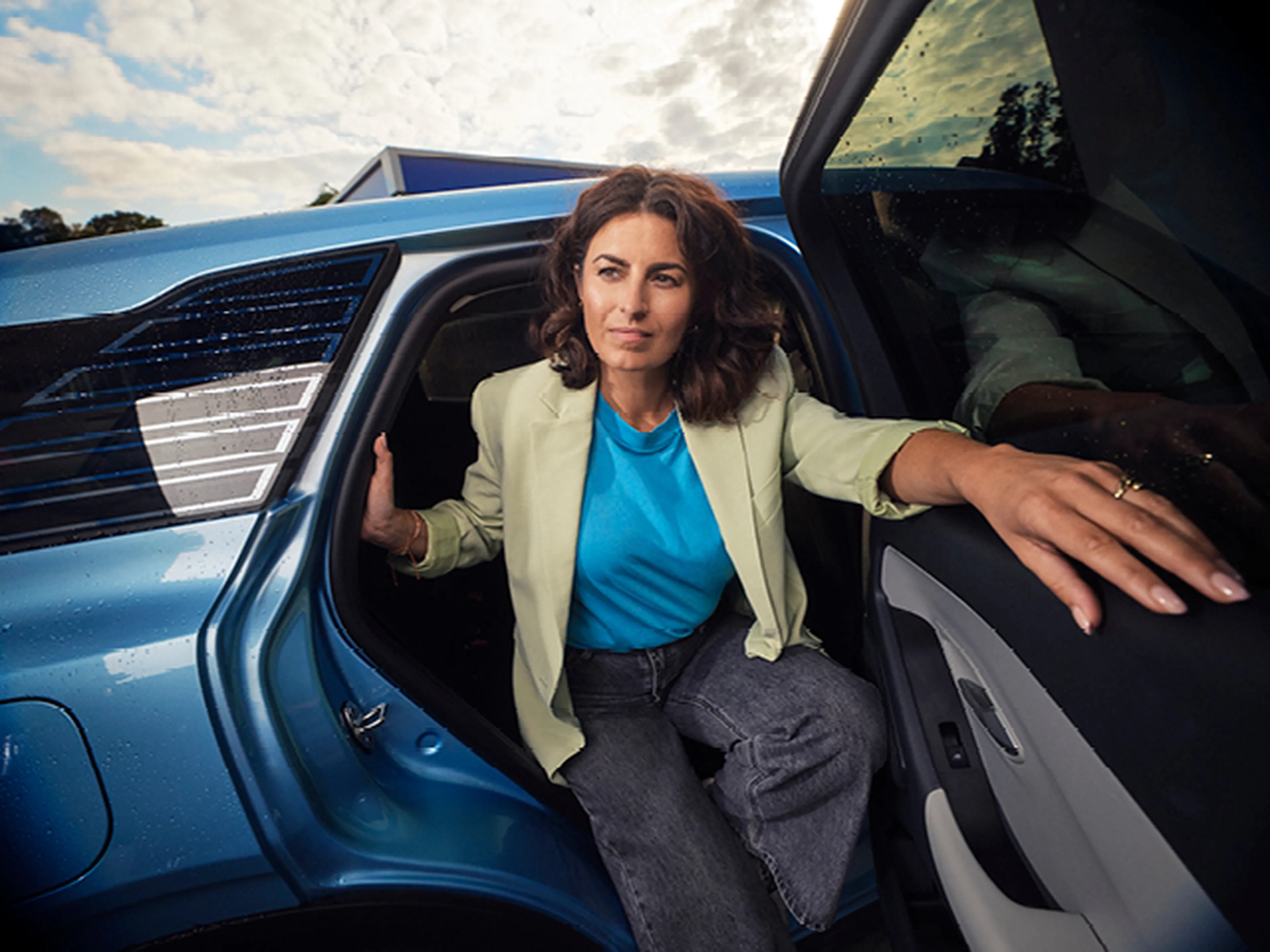 Femme sort de la voiture bleue chez Q8.​
