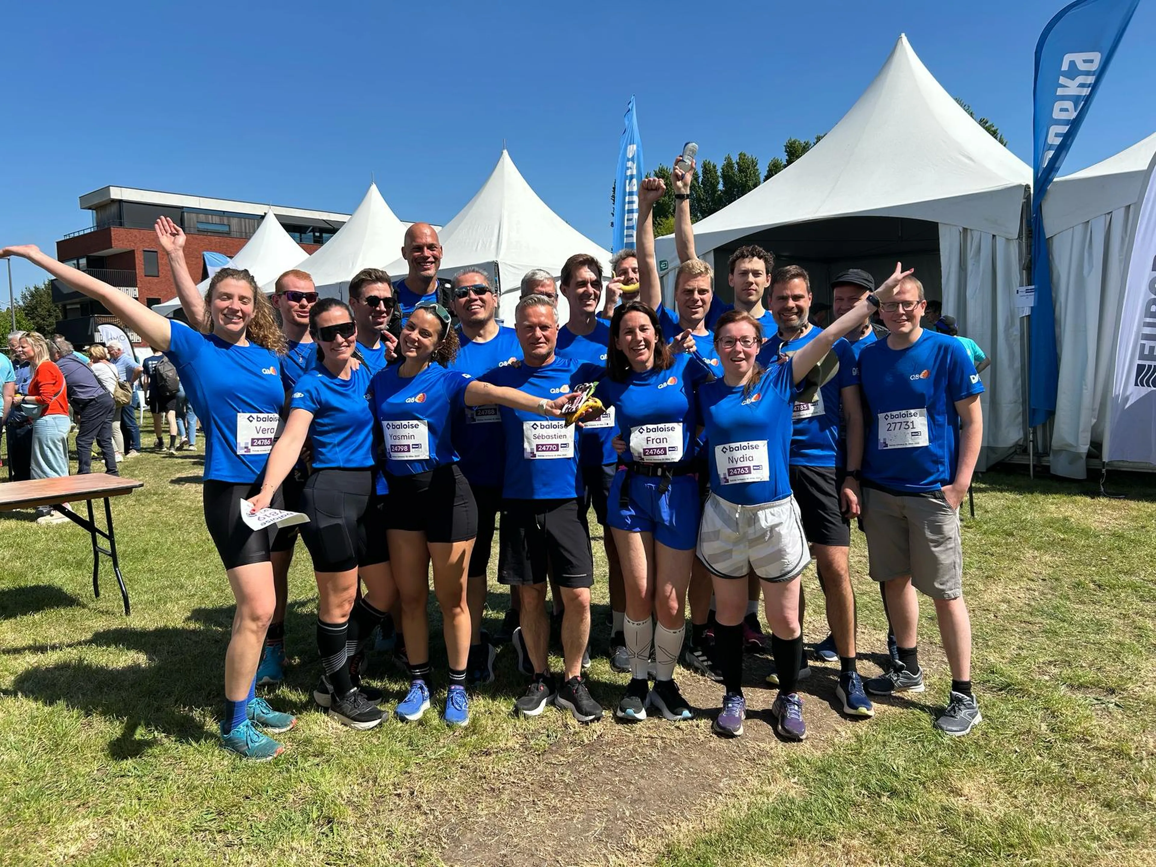 Un groupe de collègues Q8 prend une photo de groupe aux Antwerp 10 Miles.
